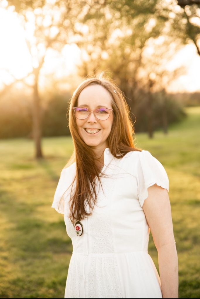 Stacia Jacobson, senior copywriter and creative strategist, smiling outdoors at golden hour
